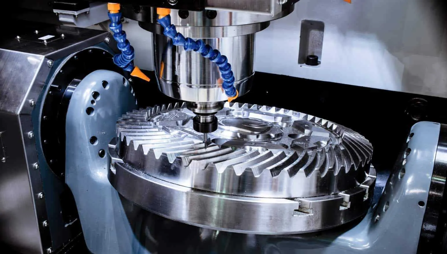 CNC machine spindle milling the teeth of a metal bevel gear